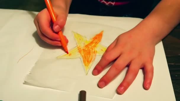 小女孩做装饰着色黄色的星星与橙色标记笔 而制作圣诞装饰在慢动作高清 — 图库视频影像