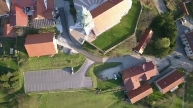 Anten: Yanında büyük park yeri ile Katolik kilisesi üzerinde uçan. Güzel bahar güneşli bir günde küçük bir köy filme.