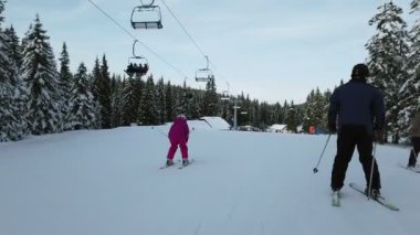 Rogla, Slovenya, 2019.01.29: nasıl kayak öğrenmek küçük kız filme. Soğuk güneşli kış gününde kızı ile dağ kayak tesisi.