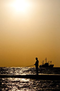 Denizde günbatımında yola çıkmak.