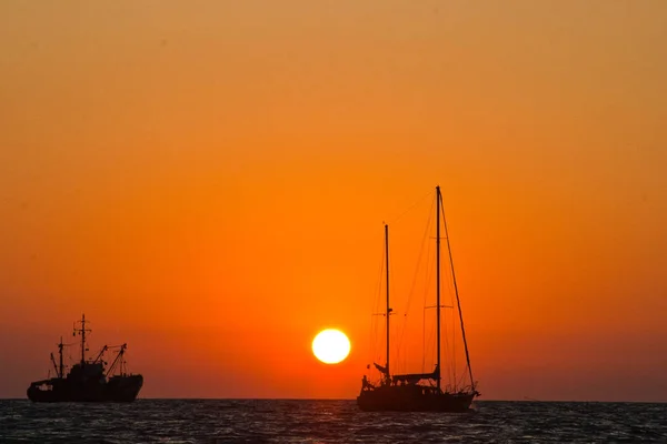 Denizde günbatımında yola çıkmak.