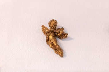 Altın melek beyaz bir arka planda keman oynuyor
