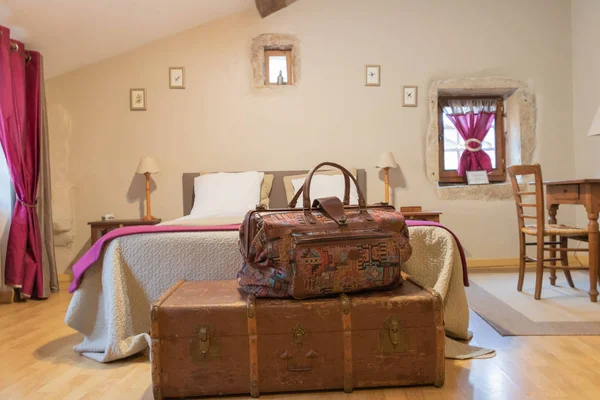Hotel room: travel bag lay on an old trunk at the foot of the bed. Vacation