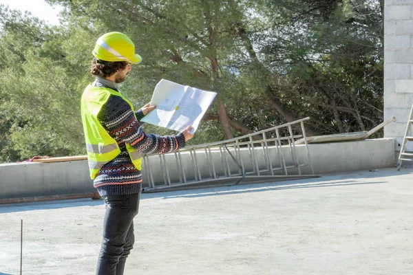 Construction site visit, architect checking the plan on the construction site of a house under construction