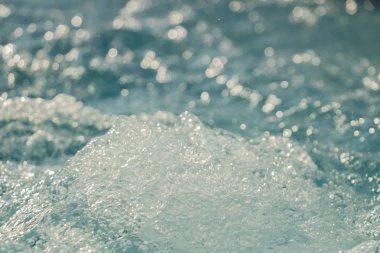 Denizde sörf, jakuzide su köpüğünde hava kabarcığı.