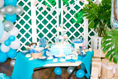 Çocuk tatil mavi balonlar, kabukları ve yeşil bitkiler ile güzel bir çikolata deniz tarzında küçük bir Doğum günü için mavi bir pasta ile dekore edilmiştir. Küçük bir çocuk için bir parti