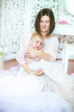 Anne ve sarılma ve birlikte oynayan kız. Sevimli küçük kız güzel kadının ellerinde.
