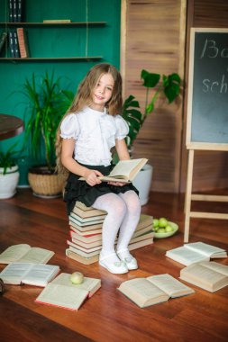 Tatlı bir kız öğrenci kitap, okul yönetimi ve elma ile uzun sarı saçlı küçük sınıfların. Okul moda