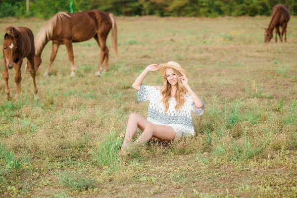 麦わら 田舎で馬の近くで光の巻き毛を持つ美しい少女の暖かい秋の晴れた日に — ストック写真