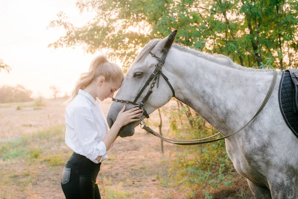 Hermosa Joven Con Pelo Claro Competencia Uniforme Abraza Caballo Retrato —  Fotos de Stock