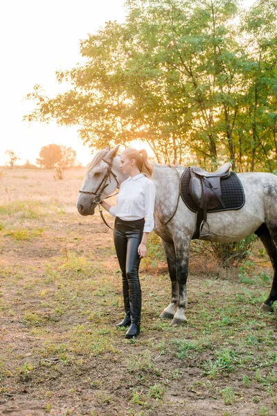 Hermosa Joven Con Pelo Claro Competencia Uniforme Abraza Caballo Retrato —  Fotos de Stock