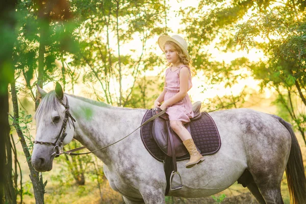 Μικρό Χαριτωμένο Κορίτσι Ελαφρά Σγουρά Μαλλιά Ένα Ψάθινο Καπέλο Ιππασία — Φωτογραφία Αρχείου