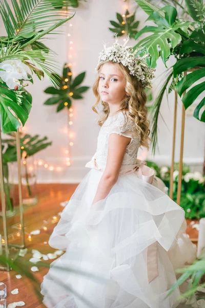 白いウェディング ドレスと熱帯の葉 白バラ 蘭の花から作られた花飾りの花の花輪のブロンドの巻き毛を持つかわいい女の子 — ストック写真