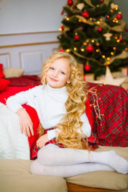 Noel sabahı, sarışın uzun kıvırcık saçlı küçük kız. Neşeli Christmas.Little kız Noel hediyesi için sevinir