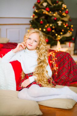 Noel sabahı, sarışın uzun kıvırcık saçlı küçük kız. Neşeli Christmas.Little kız Noel hediyesi için sevinir