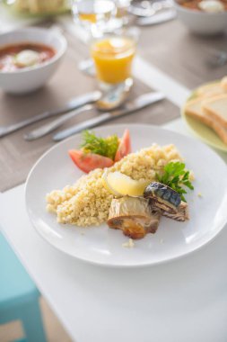 sebze ve portakal suyu ile beyaz tabakta Mısır, domates ve limon ile pişmiş balık ve rulo ile bulgur