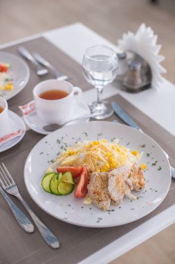 Sezar salata karides, tavuk, kruton, domates, salatalık beyaz plaka üzerinde