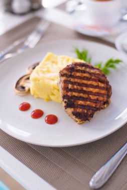 Domuz fileto etli patates püresi, mantar ve beyaz tabak salata Izgara