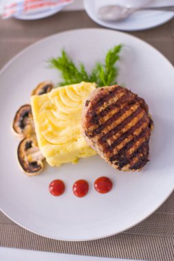 Domuz fileto etli patates püresi, mantar ve beyaz tabak salata Izgara