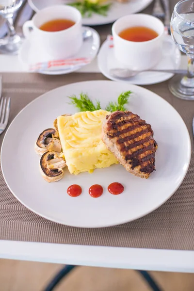 Domuz fileto etli patates püresi, mantar ve beyaz tabak salata Izgara