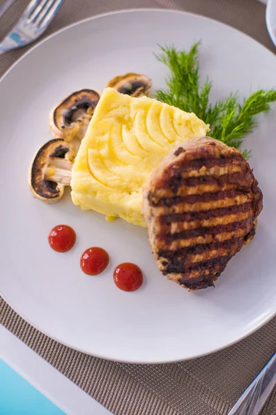 Domuz fileto etli patates püresi, mantar ve beyaz tabak salata Izgara