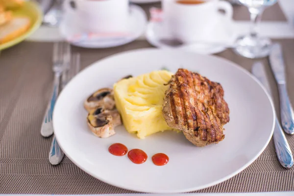 Domuz fileto etli patates püresi, mantar ve beyaz tabak salata Izgara