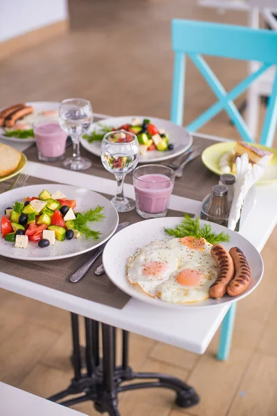 Completo Desayuno Huevos Revueltos Con Salchichas Ensalada Griega Tarta Queso —  Fotos de Stock