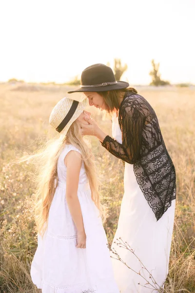 夏の晴れた日の夕日にフィールドに姉と白いドレスとブロンドの長い髪と麦わら帽子の少女 — ストック写真