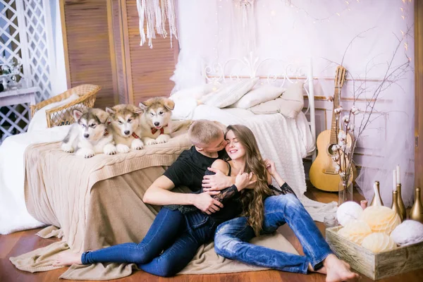 Радостная Молодая Любящая Пара Сидящая Спальне Выражающая Любовь Щенкам Маламута — стоковое фото