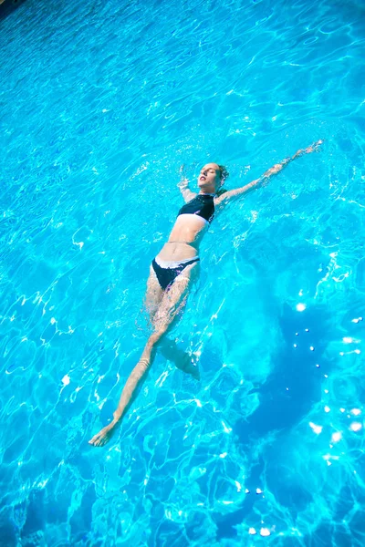 夏に屋外プールで支払っているブロンドの髪と水着姿で完璧なプロポーションを持つ美少女 — ストック写真