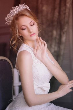 Sarı saçlı bir diadem ve beyaz peçe ve beyaz elbise genç güzel gelin