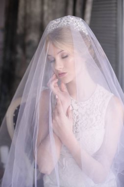 Sarı saçlı bir diadem ve beyaz peçe ve beyaz elbise genç güzel gelin