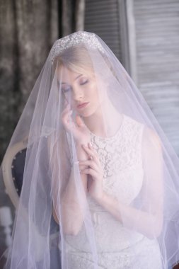 Sarı saçlı bir diadem ve beyaz peçe ve beyaz elbise genç güzel gelin