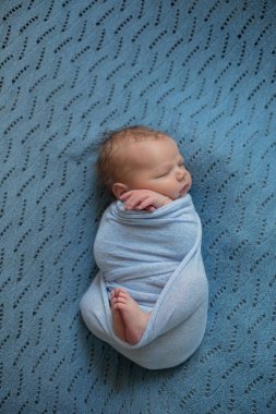 Şirin bebek mavi battaniye içinde evde yatakta uyuyor