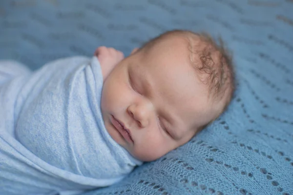 青い毛布のかわいい赤ちゃんが自宅のベッドで寝ています — ストック写真