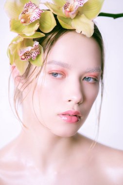 Saç yaratıcı bir makyaj ve orkide ile güzel genç kız. Bahar moda makyaj