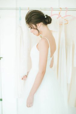 Diğer gelinlik arka planda salonda beyaz bir elbise güzel genç gelin