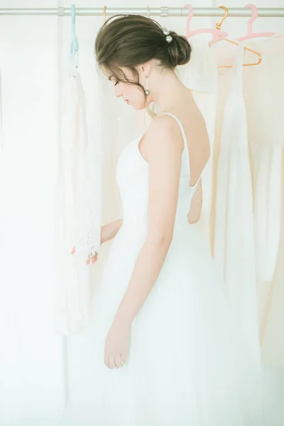 Krásná Mladá Nevěsta Bílých Šatech Salónu Pozadí Dalších Svatebních Šatů — Stock fotografie