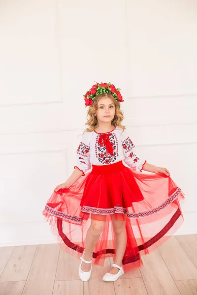 明るいスタジオで国民的なウクライナの衣装でブロンド巻き毛を持つ小さなかわいい女の子 — ストック写真