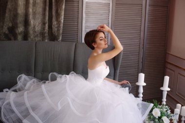 Bir stüdyoda güzel süslemeleri ile beyaz bir elbise güzel genç gelin