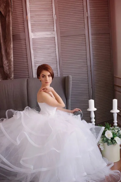 美丽的年轻新娘在一个白色的礼服与美丽的装饰在工作室 — 图库照片