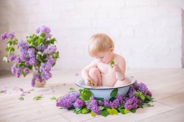 Leylak çiçekleri ile antika süt banyosunda bebek çocuk yakın