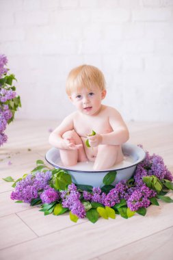 Leylak çiçekleri ile antika süt banyosunda bebek çocuk yakın