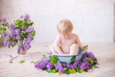 Leylak çiçekleri ile antika süt banyosunda bebek çocuk yakın