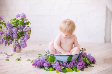 Leylak çiçekleri ile antika süt banyosunda bebek çocuk yakın