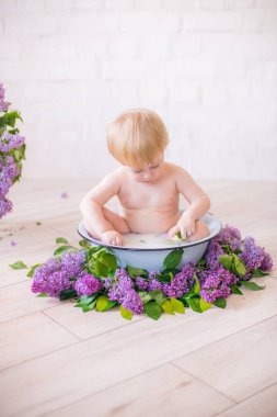 Leylak çiçekleri ile antika süt banyosunda bebek çocuk yakın