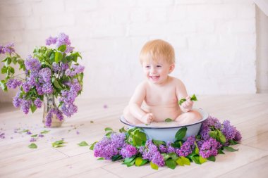 Leylak çiçekleri ile antika süt banyosunda bebek çocuk yakın