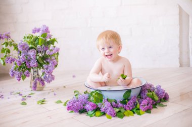 Leylak çiçekleri ile antika süt banyosunda bebek çocuk yakın