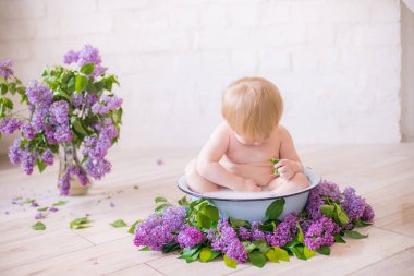 Leylak çiçekleri ile antika süt banyosunda bebek çocuk yakın