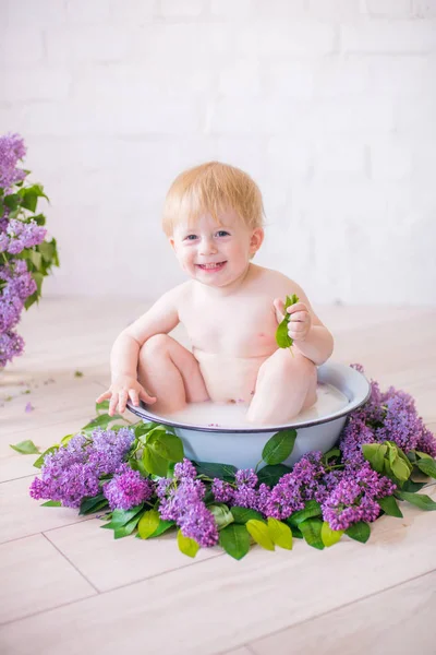 Leylak çiçekleri ile antika süt banyosunda bebek çocuk yakın